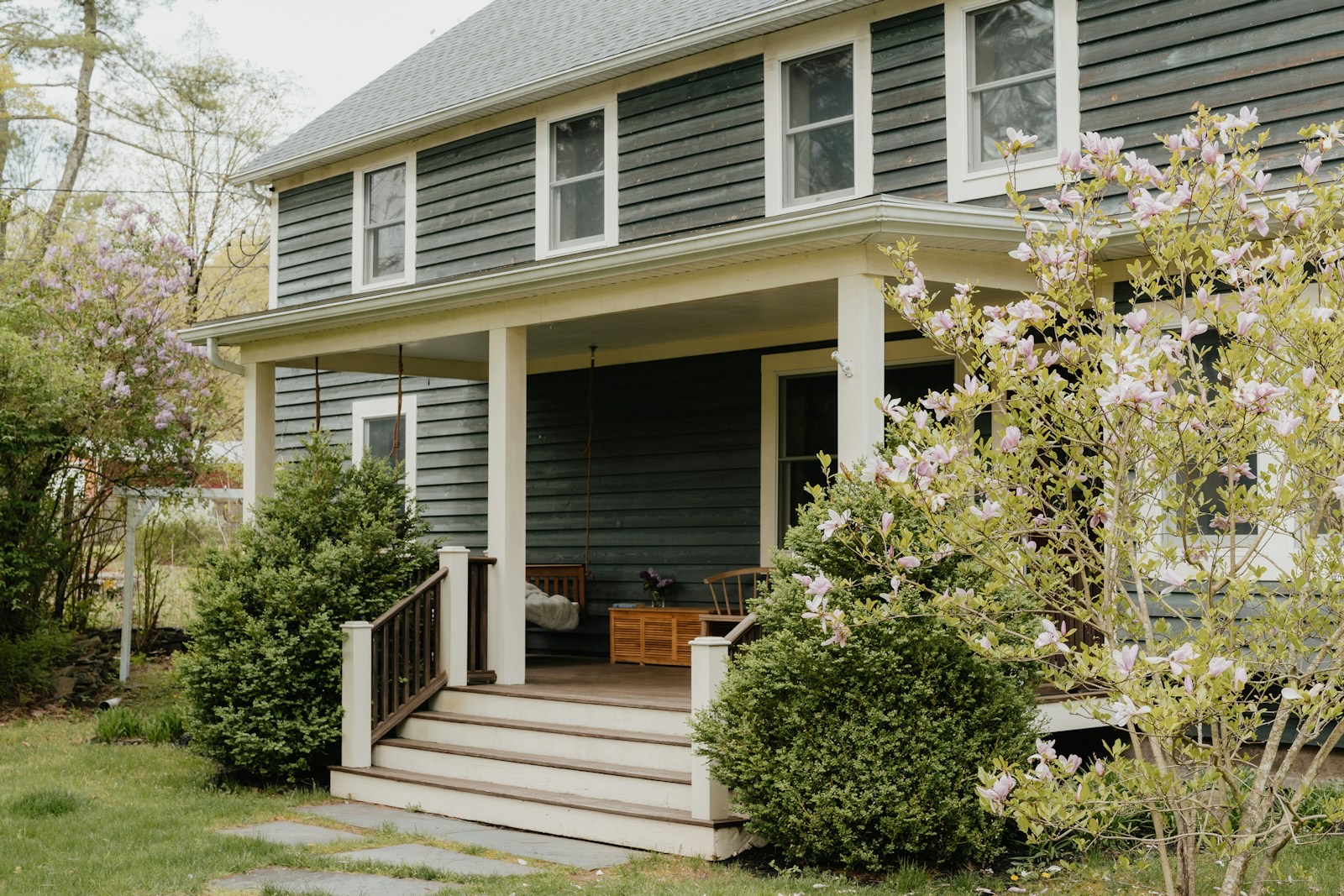 A covered front porch with a magnolia in bloom